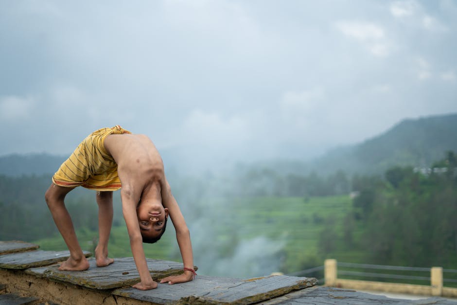 Woman practicing yoga outdoors in a peaceful setting with a lake view.